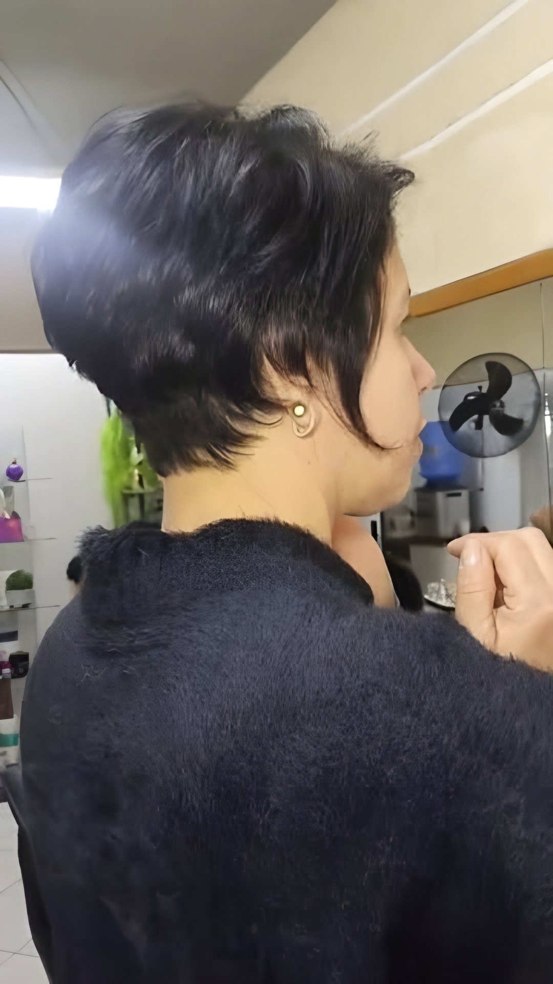 Corte pixie em cabelo preto visto de lado